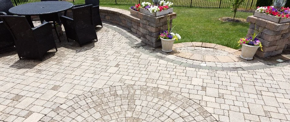Paver patio in Farmers Branch, TX, with potted plants and furniture.