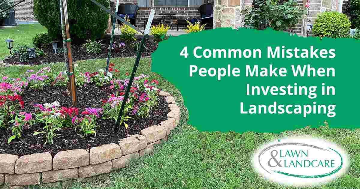 Curved residential flower bed filled with colorful flowers and dark mulch.